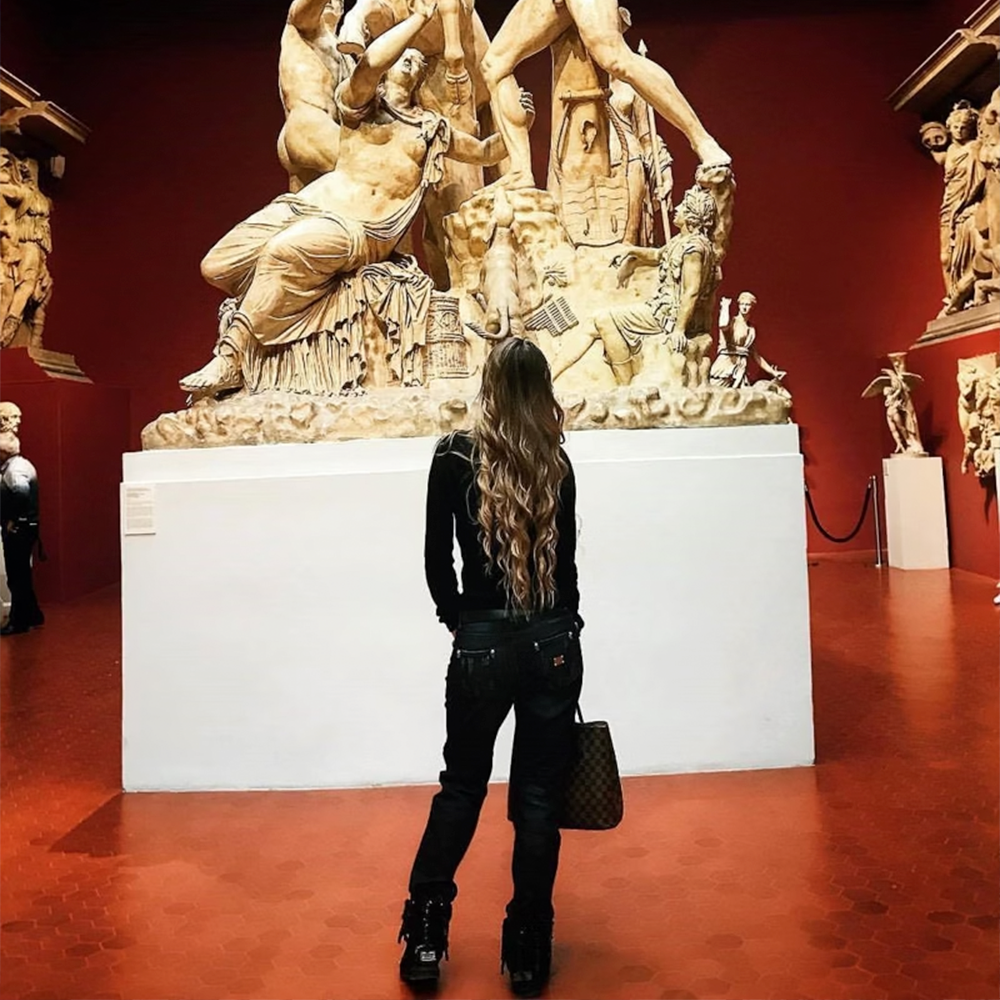Guest viewing classical sculpture in an art gallery